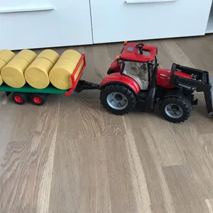 Bruder traktor koos käru ja heinapallidega.